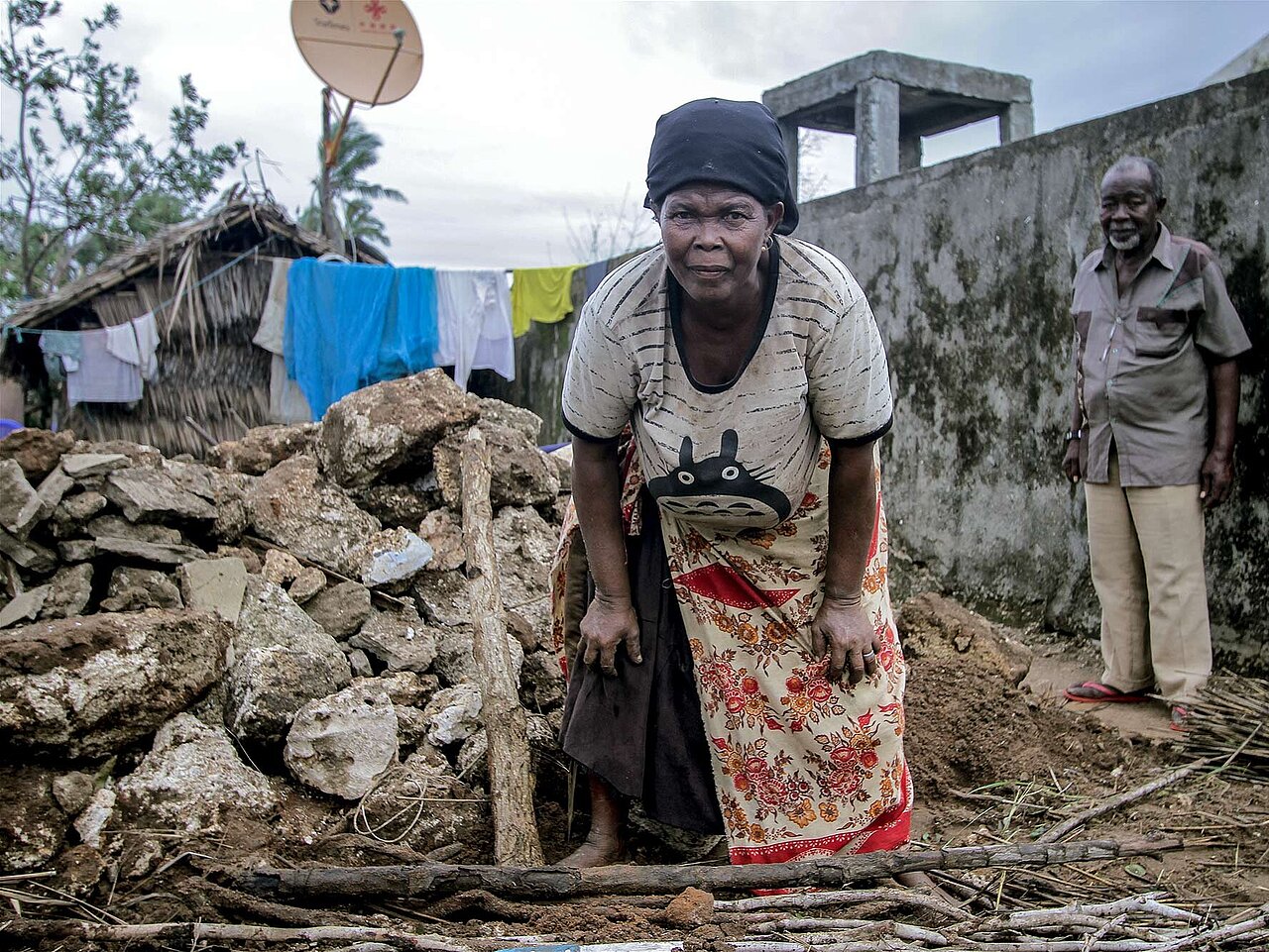 Elderly woman working in debris