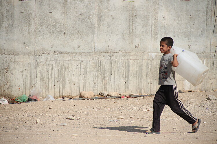 Junge im Irak während Dürre durch Klimawandel Junge mit Behälter im Irak