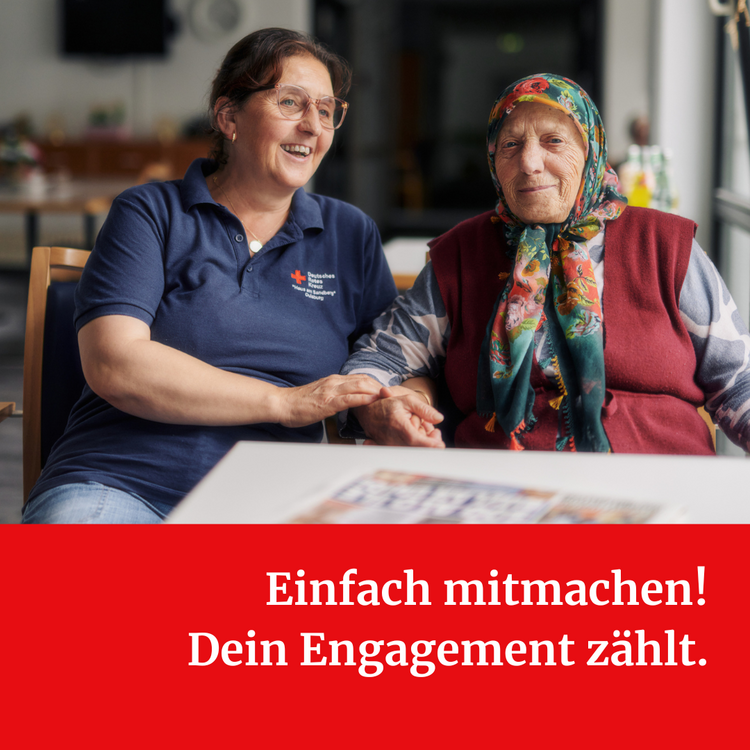 Eine Frau mit blauem T-Shirt mit Logo des DRKs sitzt neben einer alten Frau mit buntem Kopftuch und rotem Pollunder. Unter dem Foto steht "Einfach mitmachen! Dein Engagement zählt."
