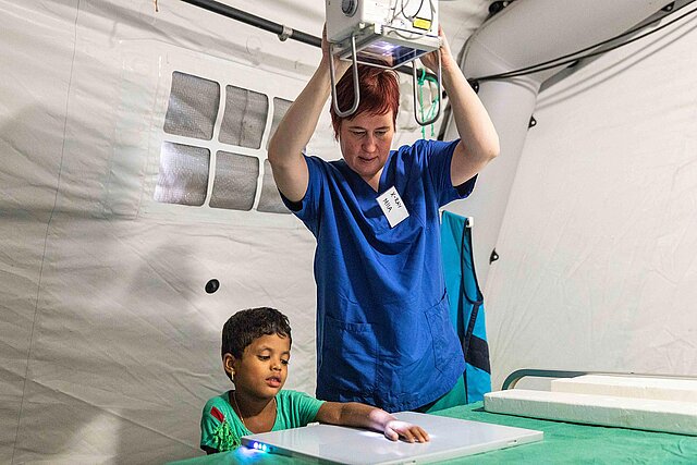 Krankenschwester beim Röntgen des Arms eines Kindes