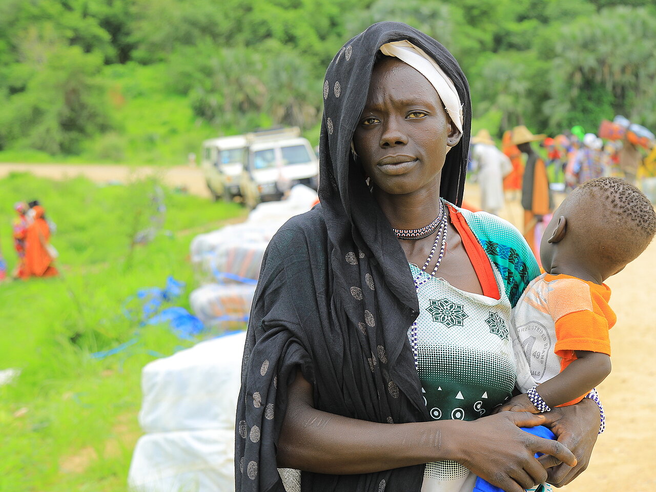 Verteilung von Hilfsgütern an Flüchtlinge aus dem Sudan durch das Äthiopische Rote Kreuz in den Orten Kurmuk und Guba an der Grenze zum Sudan. Frau mit ihrem kleinen Kind auf dem Arm