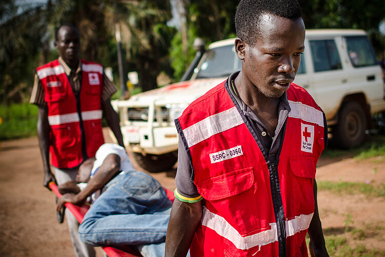 Rettungsübung in Südsudan Zwei Rotkreuz-Helfer tragen Mann auf Trage