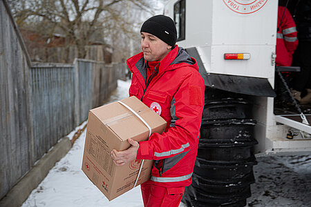 Ein Helfer des Ukrainischen Roten Kreuzes bringt Humanitäre Hilfe in abgelegene Siedlungen.