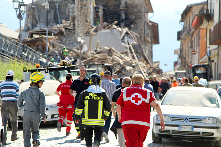 Rotkreuz-Einsatz beim Erdbeben in Italien Rotkreuz-Helfer vor Trümmern nach Erdbeben
