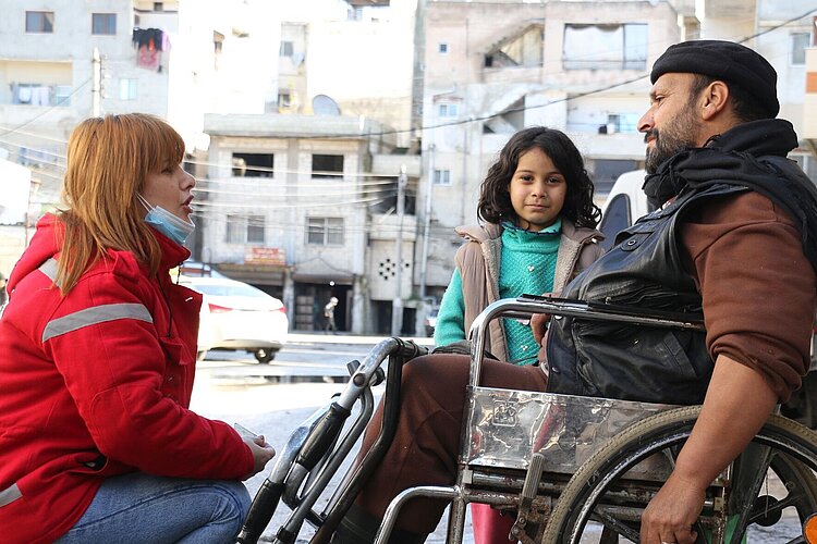 Volunteer with girl and man in wheelchair