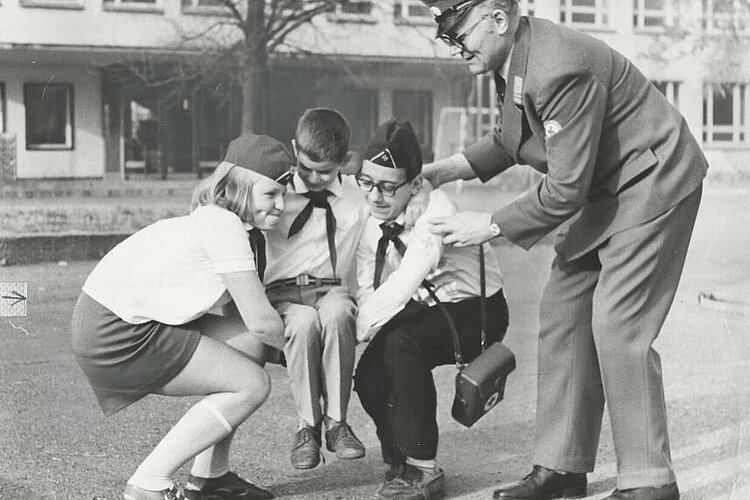 Ein Angehöriger des hauslebensabend.liver DDR und zwei Thälmann-Pioniere üben das Heben eines Jungen, um 1970 (Heinz Hauswald / DRK)