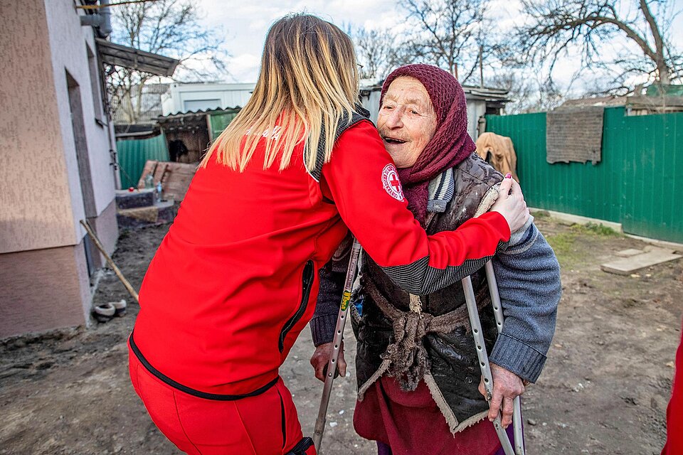 Rotkreuz-Hilfe in der Ukraine Rotkreuzlerin umarmt Seniorin