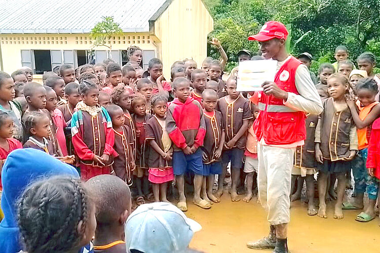 Volunteer showing children a graphic 