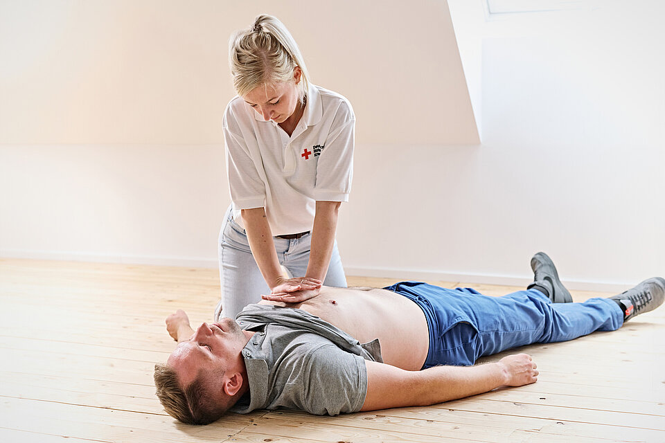 Ersthelferin bei der Herz-Lungen-Wiederbelebung bei einer Person.