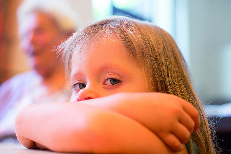 DRK-Hilfe in Deutschland Mädchen schaut über ihre verschränkten Arme