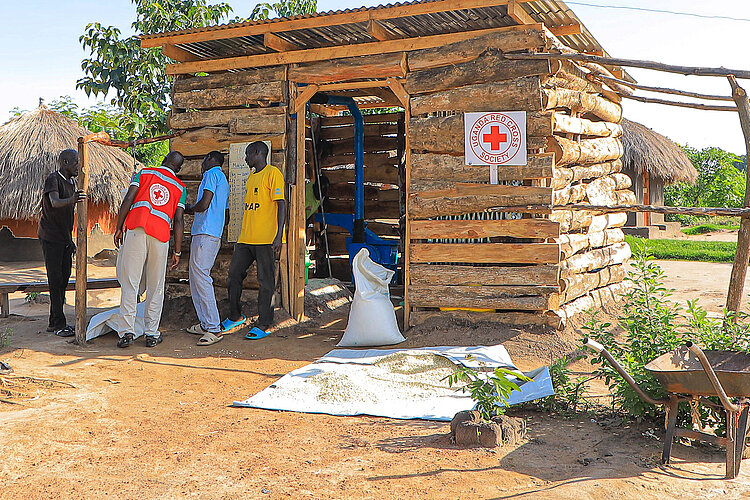 Red Cross employees in front of a mill
