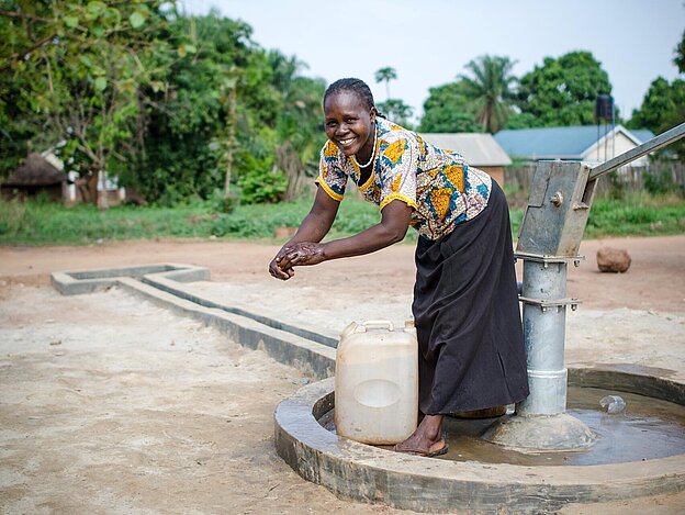Woman washing her hands at new well