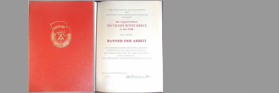 Banner der Arbeit historisches DRK-Dokument vor grauem Hintergrund