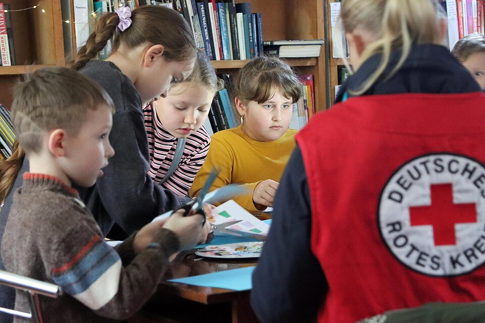 DRKlerin bastelt mit Kindern