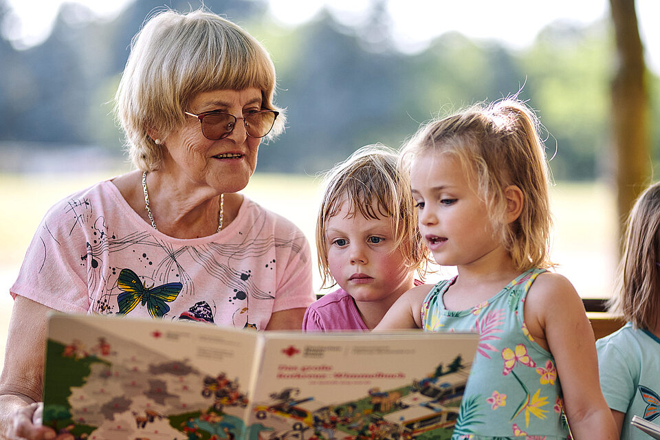 Seniorin liest Mädchen vor