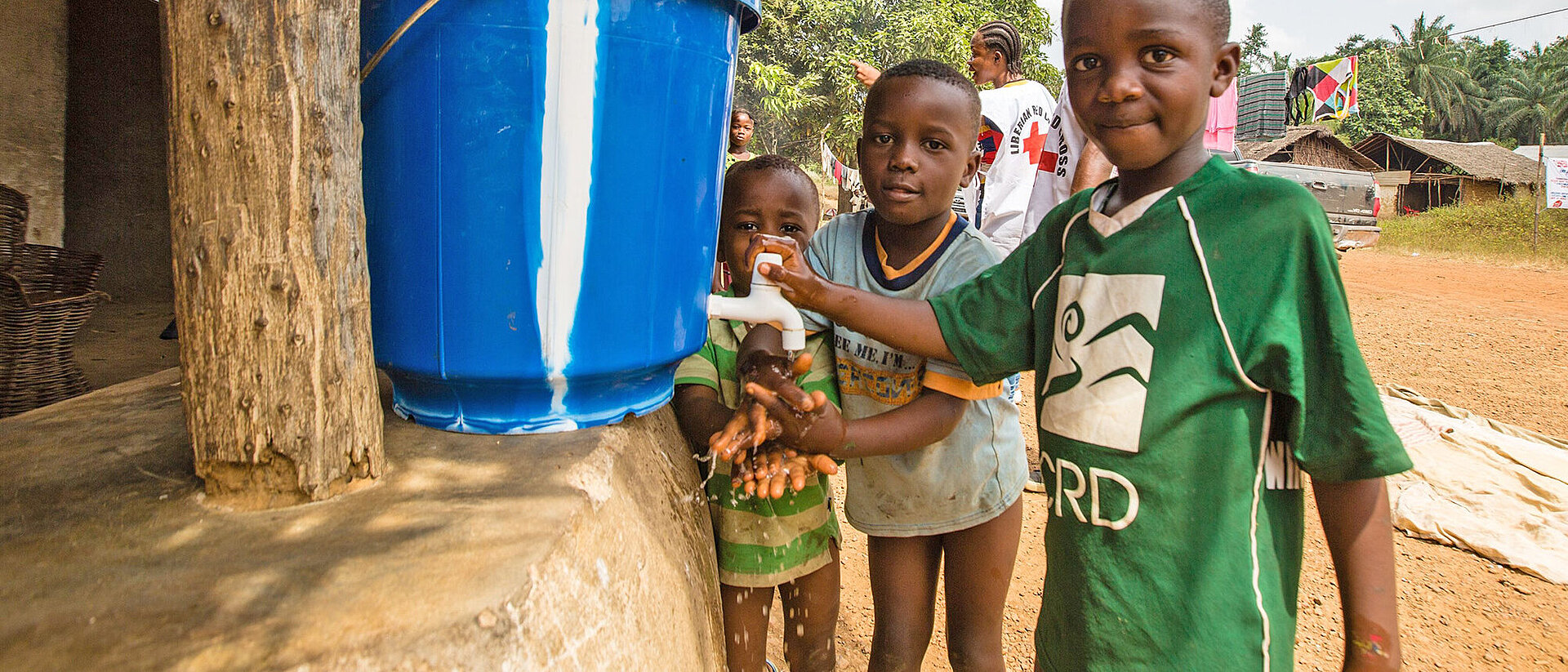 Drei Jungen in Afrika an einer Wasserstelle 