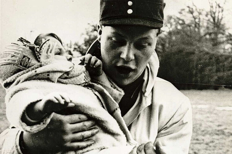 Der freiwillige Helfer Klaus-Peter Behrens mit der geretteten zweijährigen Ute Wilhelms in Hamburg (DRK)
