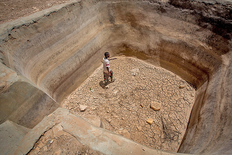 Menschen in Somalia leiden unter anhaltender Dürre Junge und ausgetrocknete Wasserquelle in Somalia
