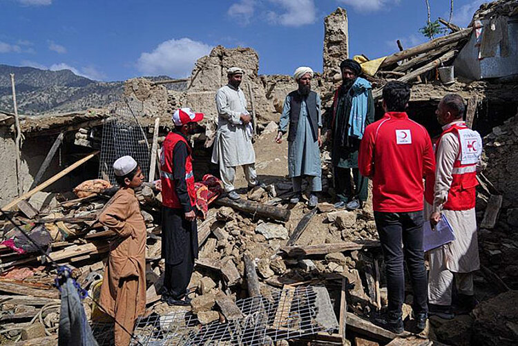 Schadenbegutachtung für optimale Hilfe in Afghanistan Männer stehen mit Helfern auf Erbbebentrümmern in Afghanistan