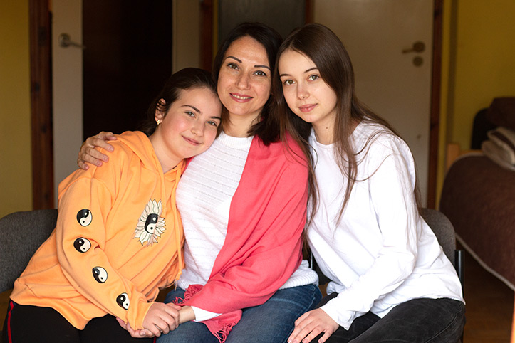 Maryna und Töchter Zwei große Mädchen schmiegen sich an Mutter